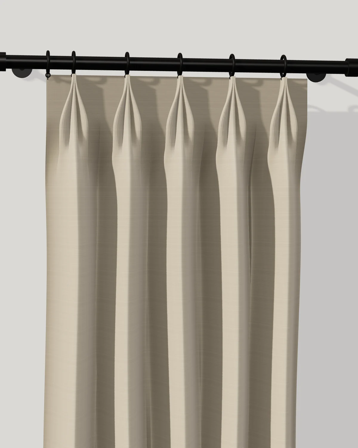 Linen French-pleat drapery on a black rod with rings. Each pleat is gathered at the very top edge and fans open below.