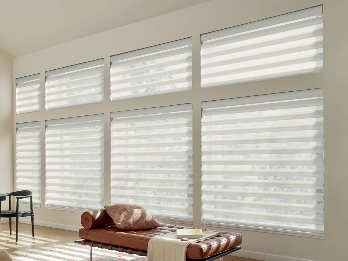 Hunter Douglas Pirouette shadings across a bank of tall windows, the contoured fabric vanes open with clear sheer gaps between them