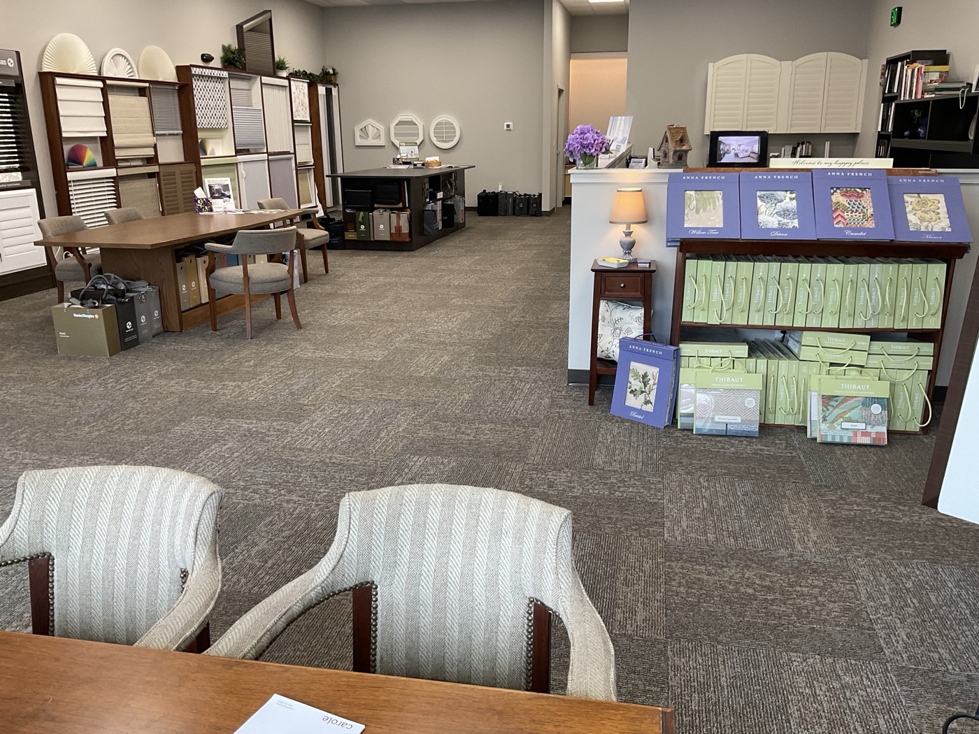 Design desk facing shelves of fabric books and arched shutter samples in the Accent on Windows showroom